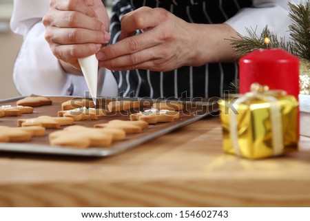 close up of the chef decorating cookies with icing sugar