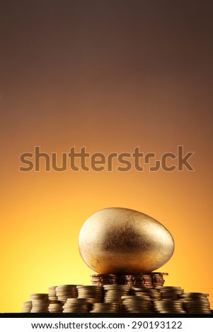 golden egg rest on stacks of coins