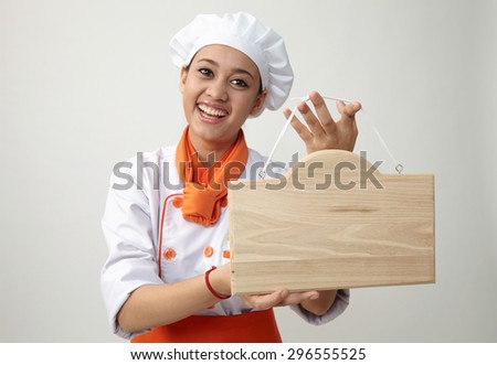 Indian woman with chef uniform holding a woden plank