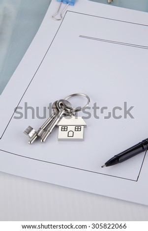 House shaped key chain with keys on top of loan application