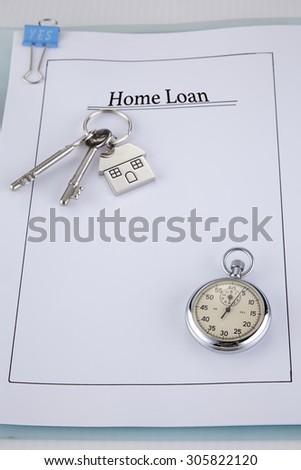 House shaped key chain with keys on top of application form