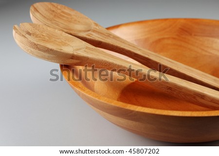 Wood plate, spoon and fork on the plain background
