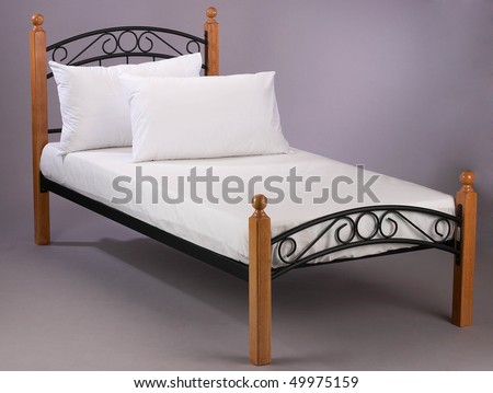 Wooden frame bed with white bed sheet.
