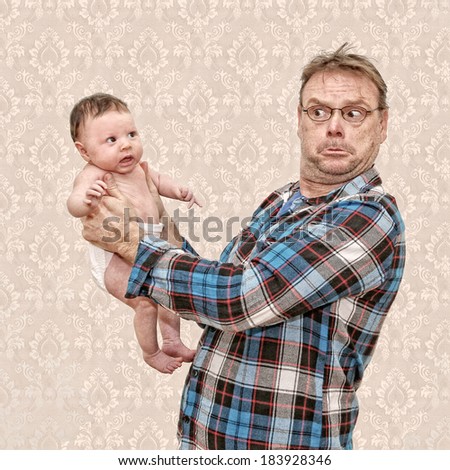 Father Holding his Young Baby with a Surprised and Confused Expression