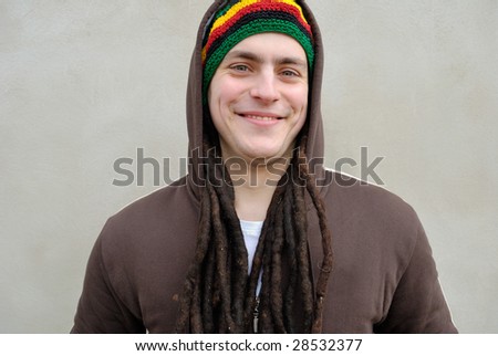 Smiling rasta man with dreadlocks in striped hat