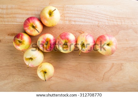 wet fuji apple on wood chop block and on wood table