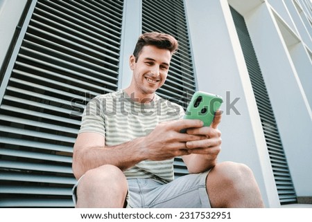 Similar – Image, Stock Photo Man using his smartphone sitting on a ledge outside