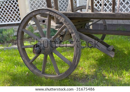 Wheel of an ancient wooden cart. A photo close up.