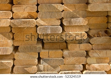 sawed wooden boards laid in a heap. An end view.