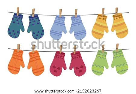 Set of different colorful mittens hanging on the rope. Wool mittens dry and hang on laundry string with clothespins. Vector illustration