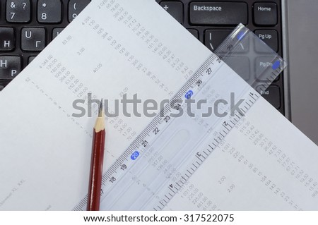 Reporting documents on the keyboard of office worker. A pencil and the consignment note on expenses.