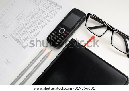 The document of the report on work with a black notebook and glasses on a table of the manager