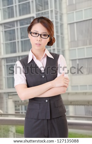 Confident business woman stand in outside of office and look at you.