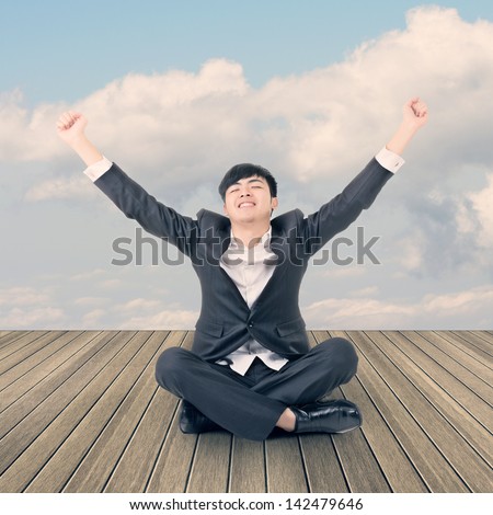 Asian business man sit on ground and open arms feel free and relax.