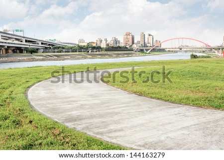 Cityscape of park near river in the city with a curved road in Taipei, Taiwan, Asia.