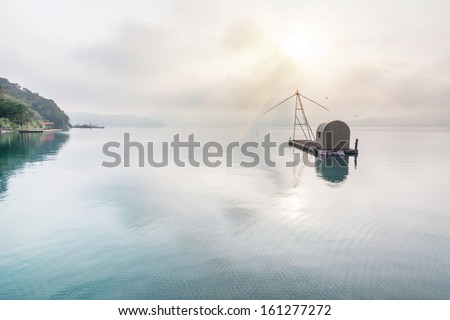 Landscape of famous Sun Moon Lake in the morning with a boat and mist in Taiwan, Asia.