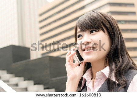 Business woman of Asian talk on cellphone, closeup portrait in urban.