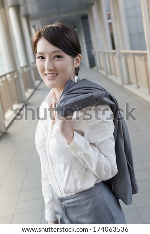Happy smiling business woman of Asian put coat on shoulder go off work.
