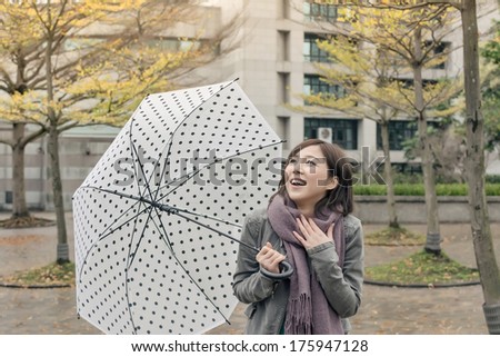 Happy smiling Asian woman holding an umbrella when rains stopped in city.