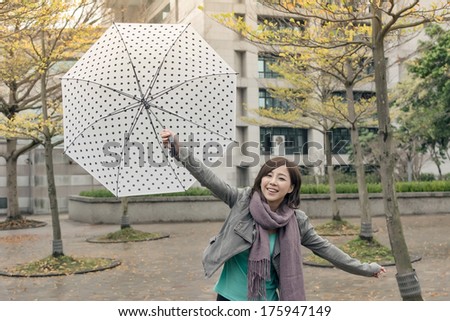 Happy smiling Asian woman holding an umbrella when rains stopped in city.