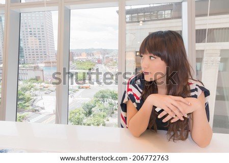 Asian woman thinking in a modern house.