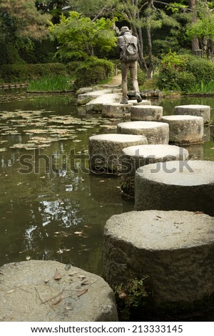 KYOTO, JAPAN - APRIL 19th : Someone walk in the zen stone path in a Japanese garden near Heian Shrine, Kyoto,  Japan. on 19th April 2014.