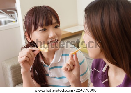 Party of lady, two women eating something in the living room.