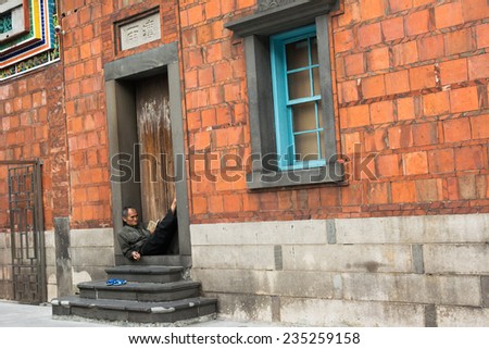 TAIPEI, TAIWAN - November 16th : Someone look scriptures and sit outside of Longshan Temple, Taiwan on November 16th, 2014.