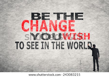 Asian businessman write text on wall, Be The Change You Wish to See in the World