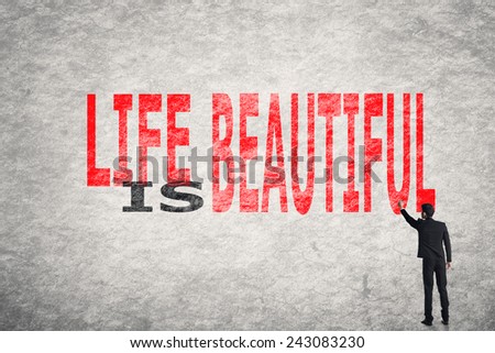 Asian businessman write text on wall, Life is Beautiful