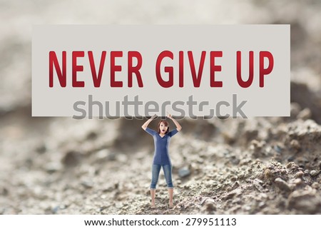 Never give up, words on blank board hold by a young girl in the outdoor.