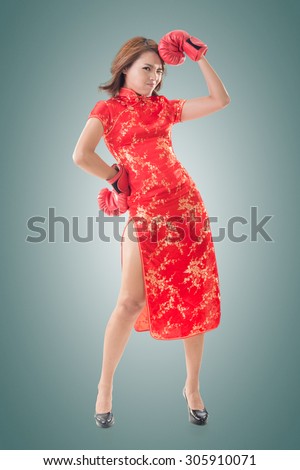 Chinese woman dress traditional cheongsam and boxing gloves, full length portrait isolated.