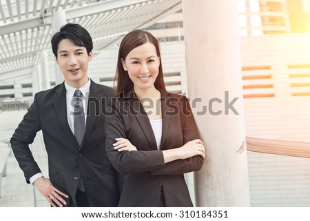 Asian business man and woman in the street, Hong Kong, China.