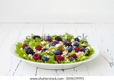 Summer refreshing mixed berry salad with pumpkin seeds, blue cheese, feta and sweet red raspberry vinaigrette. Copy space background