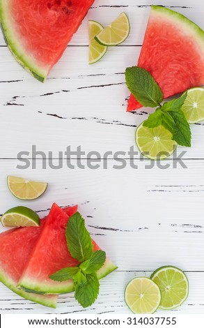 Slices of ripe juicy organic watermelon on old wooden table, served with fresh lime and mint leaves. Copy space background. Watermelon mojito ingredients