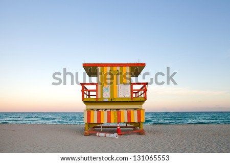 Summer scene in Miami Beach Florida, with a colorful lifeguard house in a typical Art Deco architecture, at sunset with ocean and sky in the background.