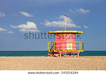 Summer scene in Miami Beach Florida, with a colorful lifeguard house in a typical Art Deco architecture, with ocean and sky in the background.