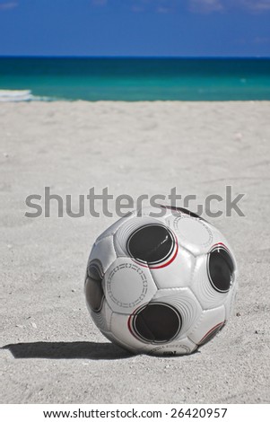 Soccer ball on Miami Beach Florida on a sunny day with blue sky and ocean background