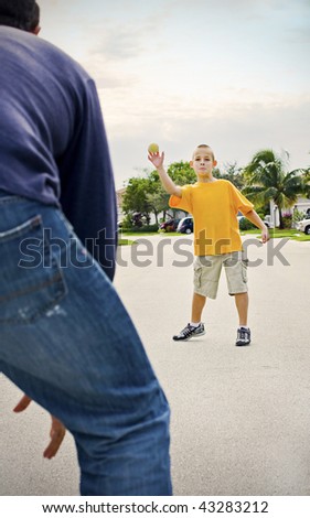 Father and son playing throw and catch in the suburbs