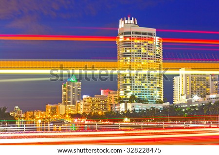Miami Beach Florida at sunset, colorful skyline of illuminated buildings and moving traffic