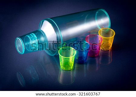 Blue cocktail shaker with colorful shot glasses