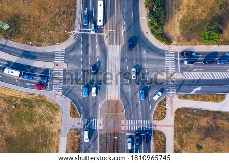 Aerial top view of crossroads with lot of vehicles or car traffic, modern urban intersections and junctions in midtown. Road traffic on crossroad or intersection downtown of European. 