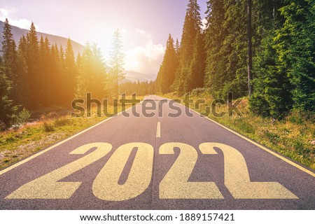 Empty asphalt road and New year 2022 concept. Driving on an empty road in the mountains to upcoming 2022. Concept for success and passing time.
