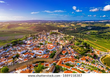Aerial view of the historic walled town of Obidos at sunset, near Lisbon, Portugal. Aerial shot of Obidos Medieval Town, Portugal. Aerial view of medieval fortress in Obidos. Portugal.