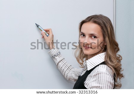 Beautiful making look younger girl beside boards with marker in hand