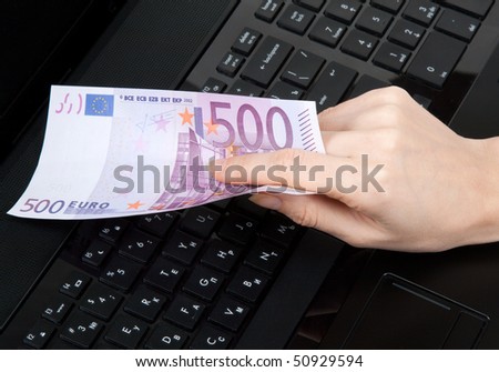 In feminine hand 500 euro on keyboard of the computer
