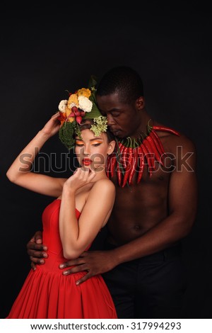 Fashion studio photo of a sensual couple. Beauty girl with Vegetables hair style. The man with red hot and spicy pepper. Two Models with creative food vegetables make up to empty copy space.