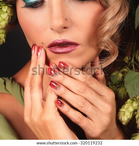 Face of beautiful woman with healthy skin and well-groomed hands over black background. Beauty in autumn concept. Beauty fashion portrait isolated on black