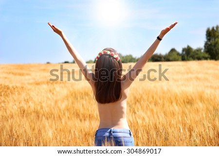 Young romantic girl with long brown hair in wheat field. Freedom. The sun is too close. Nude model. Slender girl with good figure