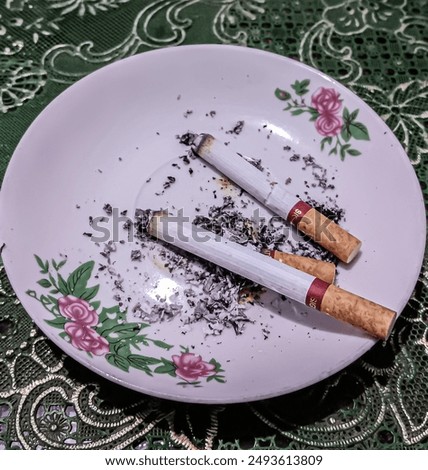 Similar – Image, Stock Photo Two cigarettes from above laying flat on pink and purple backgrounds as a symbol of female smoking